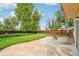 Stone patio and fire pit highlight this backyard's lush lawn and mature trees at 5262 E Sandpiper Ave, Castle Rock, CO 80104