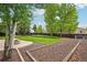 Landscaped backyard offers privacy, a stone patio with fire pit, and a mulch bed at 5262 E Sandpiper Ave, Castle Rock, CO 80104