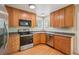 Well-lit kitchen with wood cabinets, stainless steel appliances, and hardwood-style flooring at 5262 E Sandpiper Ave, Castle Rock, CO 80104