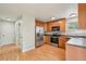 Bright kitchen with stainless steel appliances, ample wood cabinets, and access to the hallway at 5262 E Sandpiper Ave, Castle Rock, CO 80104