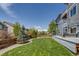 Serene backyard with lush green grass, mature trees, and a deck area at 16978 W 87Th Ave, Arvada, CO 80007