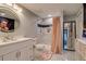 Bathroom featuring modern finishes, a walk-in shower, and a round mirror at 16978 W 87Th Ave, Arvada, CO 80007