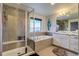 Bright bathroom featuring a separate tiled shower, soaking tub and double vanity with white cabinetry at 16978 W 87Th Ave, Arvada, CO 80007
