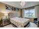 Bedroom with a tufted headboard, chandelier, and bright natural light from the window at 16978 W 87Th Ave, Arvada, CO 80007