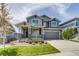 Charming two-story home featuring a covered porch, manicured lawn, and attached two car garage at 16978 W 87Th Ave, Arvada, CO 80007