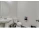 Clean and modern half bathroom featuring a pedestal sink, round mirror, and neutral decor at 16978 W 87Th Ave, Arvada, CO 80007