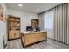 Well-lit home office with a large desk, built-in shelving, and a comfortable workspace for productivity at 16978 W 87Th Ave, Arvada, CO 80007