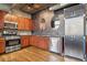 Updated kitchen features stainless appliances, wood cabinets, and modern backsplash at 1720 Wazee St # 2B, Denver, CO 80202