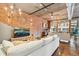 Bright living room boasts brick accent wall, wood floors, modern light fixtures, and brick accent wall at 1720 Wazee St # 2B, Denver, CO 80202