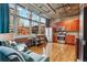Bright living room and kitchen with wood floors, stainless appliances, and large windows at 1720 Wazee St # 2B, Denver, CO 80202
