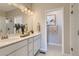 Neutral bathroom with dual sink vanity, large mirror, and tiled walk-in shower at 6807 Huddersfield Ln, Castle Pines, CO 80108
