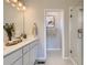 Neutral bathroom with dual sink vanity, large mirror, and glass shower at 6807 Huddersfield Ln, Castle Pines, CO 80108