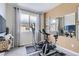Home exercise room features exercise bike, eliptical and large window at 6807 Huddersfield Ln, Castle Pines, CO 80108