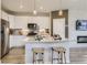 Modern kitchen with white cabinetry, stainless appliances, granite countertops, and a central island at 6807 Huddersfield Ln, Castle Pines, CO 80108
