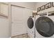 A bright laundry room features a modern washer and dryer plus a handy storage closet at 6807 Huddersfield Ln, Castle Pines, CO 80108