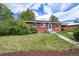 Charming red brick ranch-style home with a well-manicured lawn and mature landscaping at 1646 S Stuart St, Denver, CO 80219