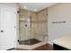 Modern bathroom with a glass-enclosed shower featuring tiled walls, a built-in bench, and granite countertop at 14022 E Fair Pl, Centennial, CO 80111