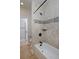 Bathroom with shower-tub combo and neutral tile surround at 14022 E Fair Pl, Centennial, CO 80111