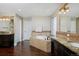 Spacious bathroom featuring a soaking tub with stone accents and double vanity with granite countertops at 14022 E Fair Pl, Centennial, CO 80111