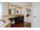 Well-lit bathroom featuring a vanity with a granite countertop, a large mirror, and access to the bedroom at 14022 E Fair Pl, Centennial, CO 80111
