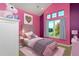 Staged bedroom with colorful walls, soft carpet, and a small bed at 14022 E Fair Pl, Centennial, CO 80111