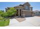 Charming home featuring a stone and brown exterior, well-manicured landscaping, and attached garage at 14022 E Fair Pl, Centennial, CO 80111