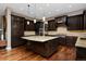 Gourmet kitchen boasts dark wood cabinets, granite countertops, and a large center island at 14022 E Fair Pl, Centennial, CO 80111