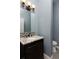 Powder room featuring a vanity with granite countertops and decorative mirror at 14022 E Fair Pl, Centennial, CO 80111