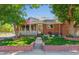 Inviting brick home with well-maintained front yard, featuring an American flag and mature landscaping at 1922 Graves Ct, Northglenn, CO 80233