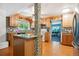 Bright kitchen with wood cabinets, island, granite counters, tile backsplash and stainless steel refrigerator at 1922 Graves Ct, Northglenn, CO 80233