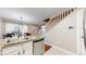 Open-concept kitchen featuring stainless steel appliances, granite countertops, and a view of the staircase and the front door at 1381 W 112Th Ave # B, Westminster, CO 80234