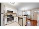 Bright kitchen featuring stainless steel appliances, including a dishwasher and stove, an island, and hardwood floors at 1381 W 112Th Ave # B, Westminster, CO 80234