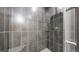 Modern tiled shower featuring glass shelving, a shower head, and neutral finishes at 1381 W 112Th Ave # B, Westminster, CO 80234