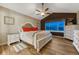 Bright bedroom featuring a decorative white bed frame, ceiling fan, wood floors, and large window at 1497 Bent Grass Cir, Castle Rock, CO 80109