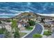 A neighborhood view showing homes along a curved street with a mountain in the distance at 1497 Bent Grass Cir, Castle Rock, CO 80109