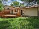 Backyard view showcasing the wooden deck attached to the house amidst the lush greenery at 18249 E Mexico Pl, Aurora, CO 80017