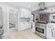 Bright kitchen featuring white cabinets, stainless steel appliances, and a view into hallway at 3924 Xavier St, Denver, CO 80212