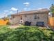 Backyard features brick home, grass, small patio, and BBQ grill at 4151 S Lewiston Cir, Aurora, CO 80013