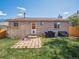 Backyard features brick home, grass, small patio, and BBQ grill at 4151 S Lewiston Cir, Aurora, CO 80013