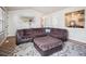 Spacious living room with brown sectional, patterned rug, and open layout to dining area at 4151 S Lewiston Cir, Aurora, CO 80013