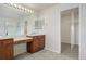 Bright bathroom features double sinks, cherry wood cabinets, glass shower, and ample mirrors at 7054 S Fultondale Cir, Aurora, CO 80016