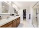 Bathroom suite featuring double sinks, a large mirror, a glass shower and closet access at 3744 Gypsum Ct, Superior, CO 80027