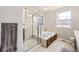 Bright bathroom featuring a separate shower and tub, neutral tile and a large window at 3744 Gypsum Ct, Superior, CO 80027