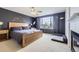 Comfortable main bedroom suite with a large window, dark accent wall, ceiling fan and fireplace at 3744 Gypsum Ct, Superior, CO 80027