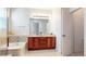 Bright bathroom featuring double vanity with cherry wood cabinets and travertine tile at 14230 Lakeview Ln, Broomfield, CO 80023