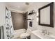 A tiled bathtub and shower combination are featured in this bathroom with modern lighting, shelves and a framed mirror at 800 Illinois St # 1, Golden, CO 80401