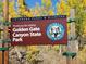 Sign for Golden Gate Canyon State Park in Colorado amidst vibrant autumn foliage at 800 Illinois St # 1, Golden, CO 80401