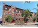 Brick apartment building with red doors and landscaping at 521 E 14Th Ave # 18, Denver, CO 80203