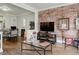 Living area with exposed brick wall, hardwood floors, and flat-screen TV at 521 E 14Th Ave # 18, Denver, CO 80203