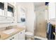 Well-lit bathroom featuring a glass-enclosed shower, storage cabinets and modern fixtures at 7350 Devinney Ct, Arvada, CO 80005